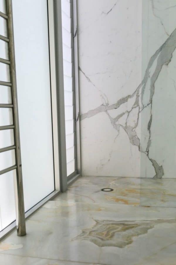 calacatta shower wall and white onyx floor